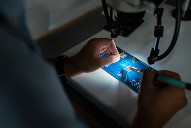 A Technician soldering with a microscope